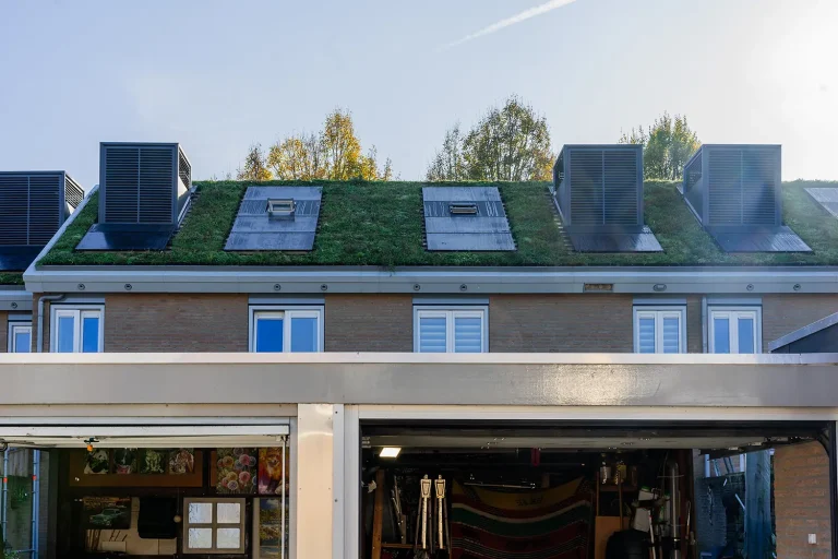 Moderne gebouwgevel met dakramen en grote glaspartijen.