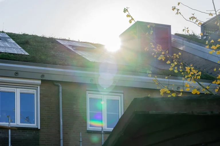 Dakraam in een donkere ruimte met fel zonlicht dat door het glas valt.