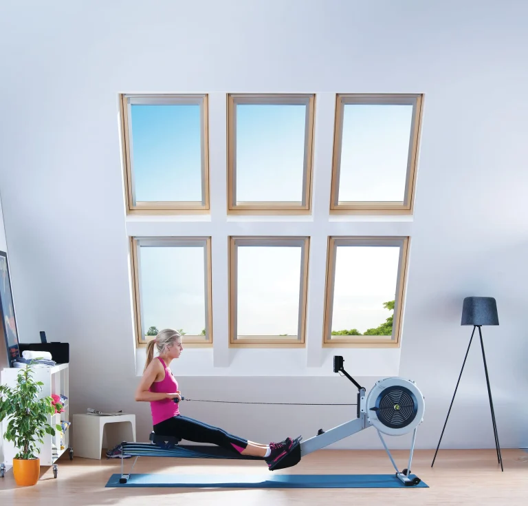 Roeimachine in een lichte fitnessruimte met zes Keylite combinatiedakramen.