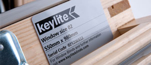 Oud Keylite typeplaatje op een houten dakraam met productgegevens.